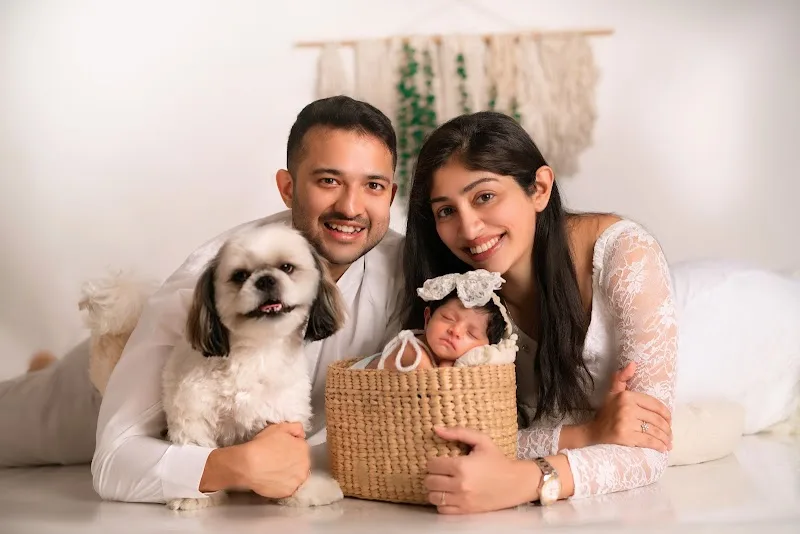 Parents, their newborn and family dog posed together