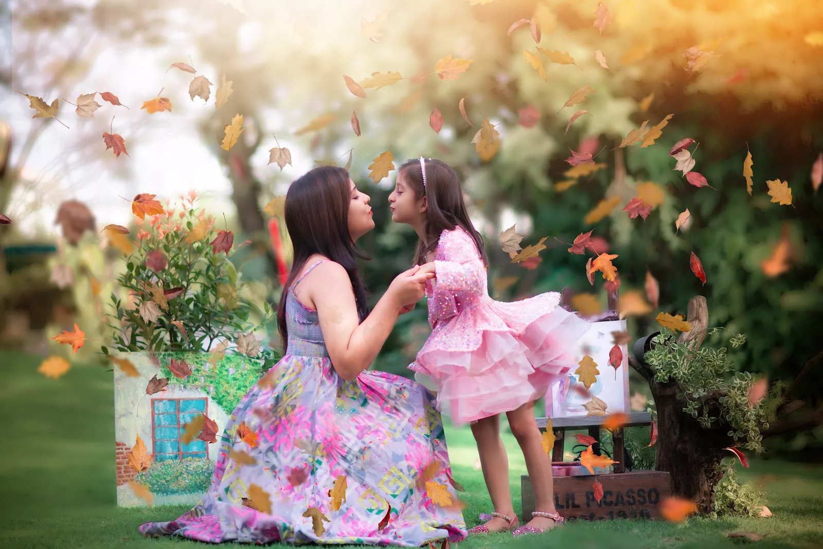 Mother and daughter surrounded by falling autumn leaves