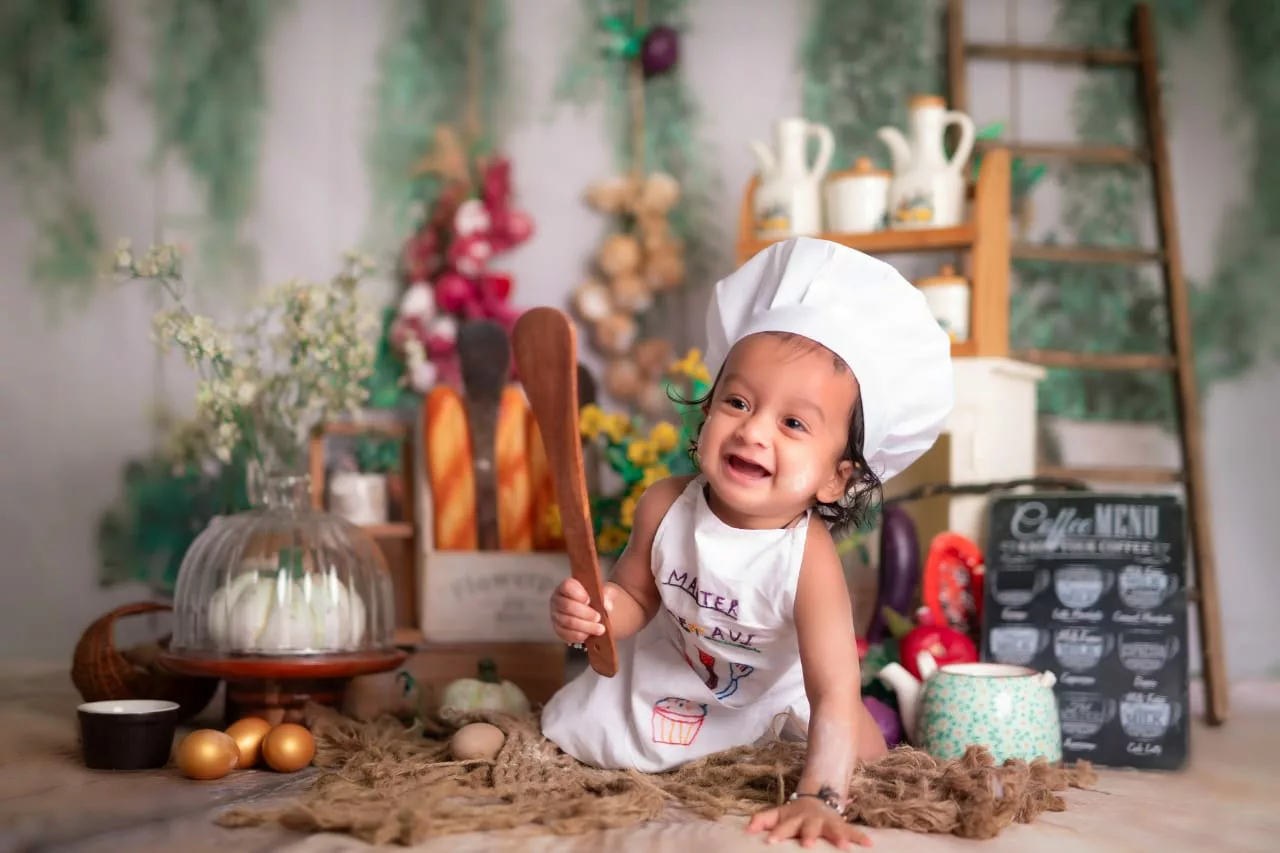Smiling baby dressed as a chef