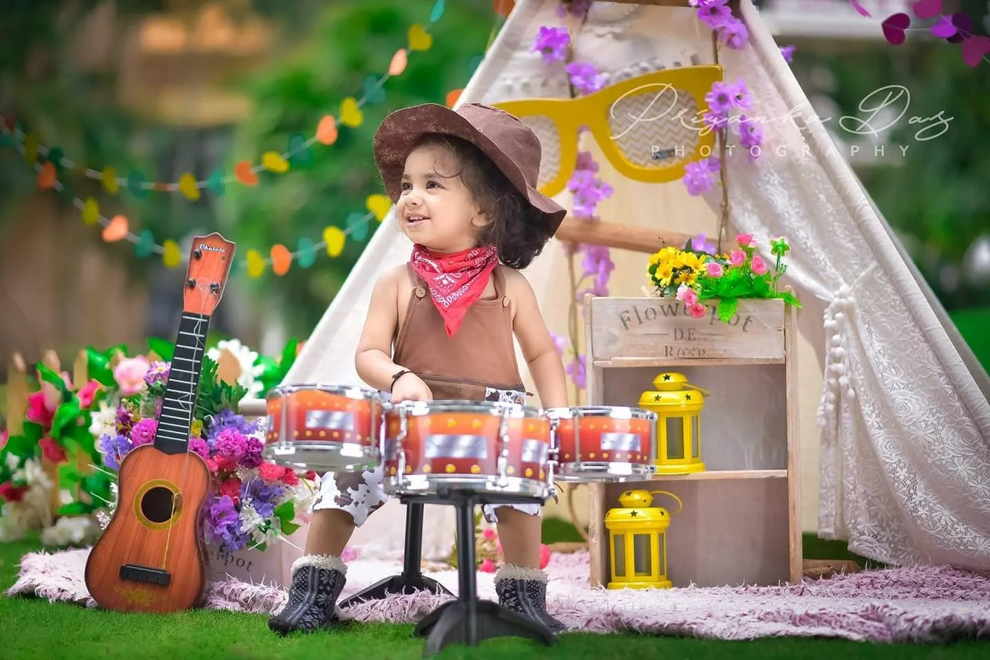 Happy toddler playing a small drum set outdoors