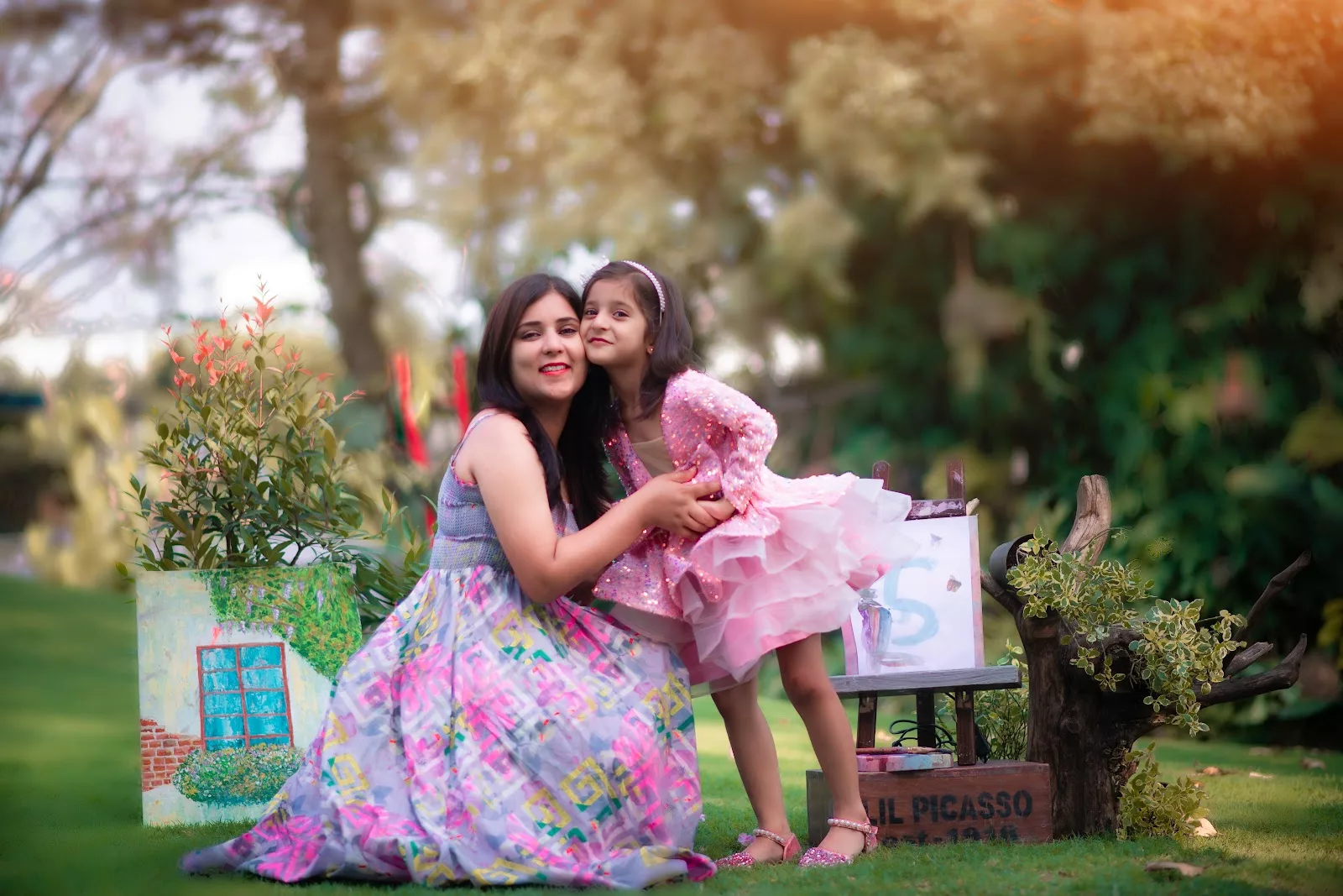 Mother embracing her daughter beside an easel