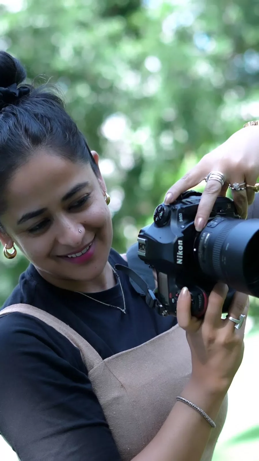 Priyanka smiling while reviewing a photograph on her camera